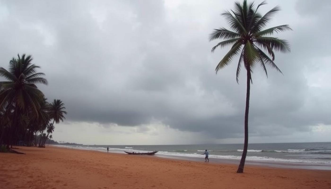 Moody Goa beach in monsoon with grey clouds, palm trees and empty sand